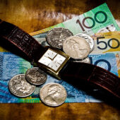 Time is money. Australian currency and a wrist watch.