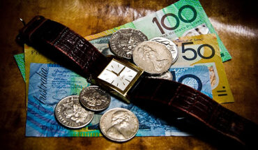 Time is money. Australian currency and a wrist watch.