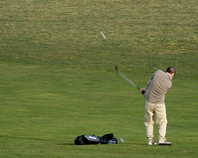 Amateur golfer hitting a ball.
