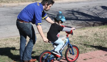 Man teaching child how to ride a bike