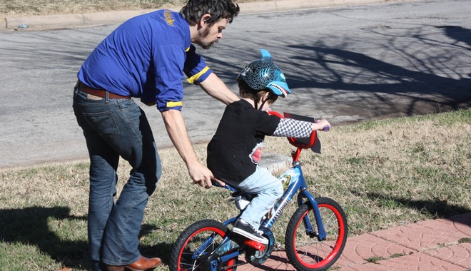 Man teaching child how to ride a bike
