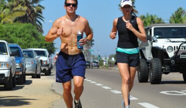 2 people running alongside a highway